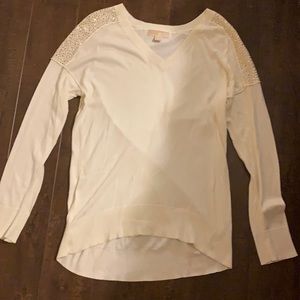 A white v-neck blouse with rin stones